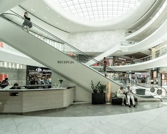 Shopping mall atrium with escalators.