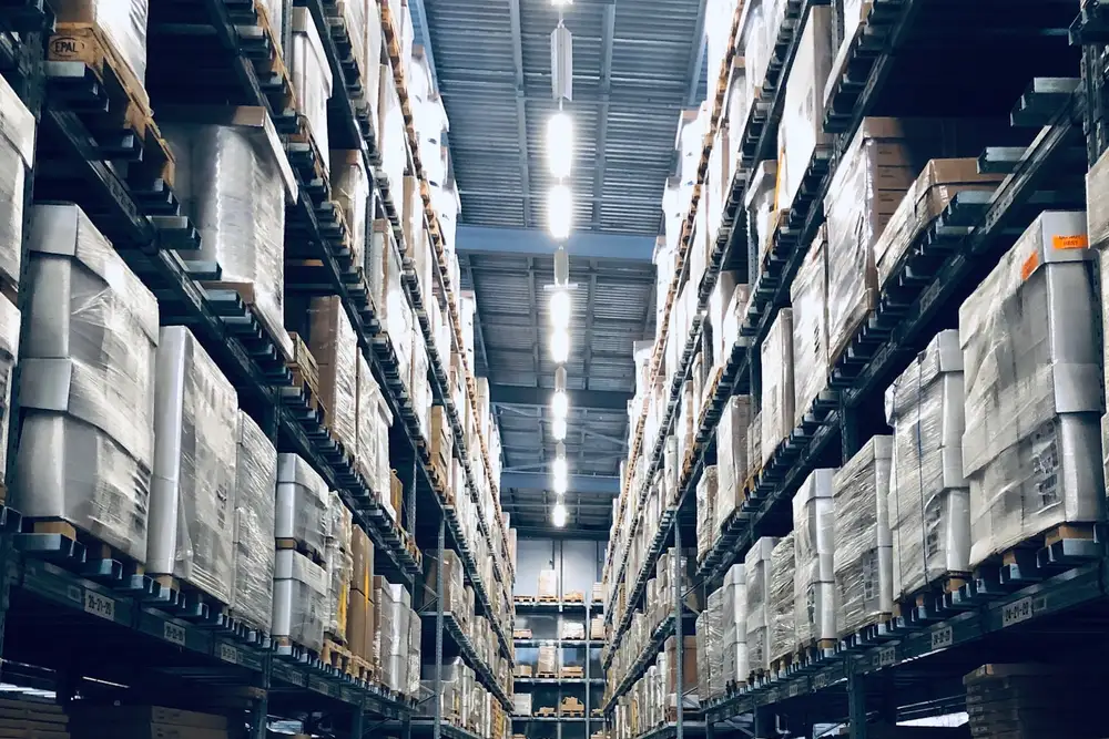 Stocked warehouse aisle with racked cases.